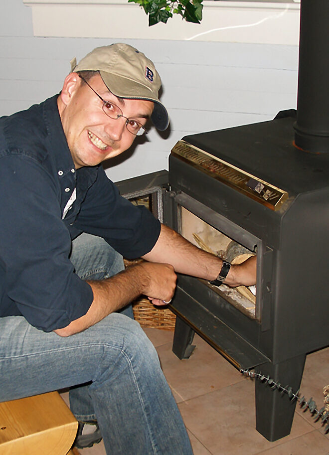 An excited guest getting to build a fire in his heritage cabin stove at Cross River